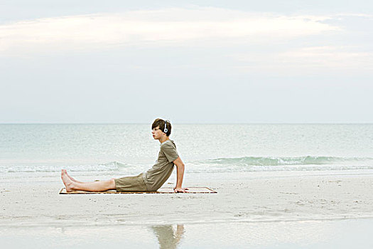 少男,坐,海滩,听,耳机,侧面视角