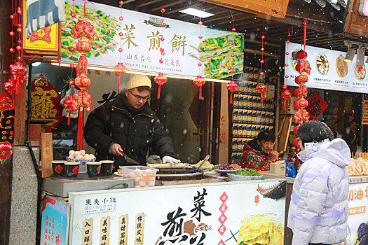 山东省日照市,游客踏雪逛美食街,感受不一样的元宵佳节