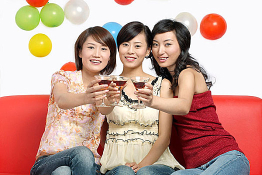 生日会上举杯庆祝的三个年轻女人