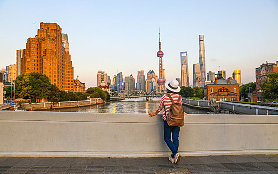 站在苏州河桥上欣赏上海城市风光的女游客背影,上海旅游概念