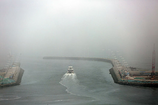 山东省日照市,海边冷暖空气交汇,云雾变化多端环绕百米高楼