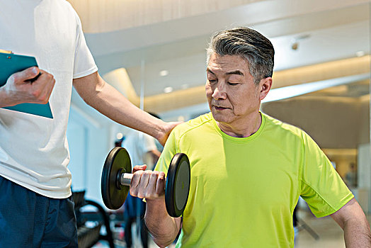 老年男子在私教的指导下健身