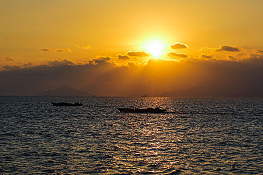 大海日出与渔船相映成景