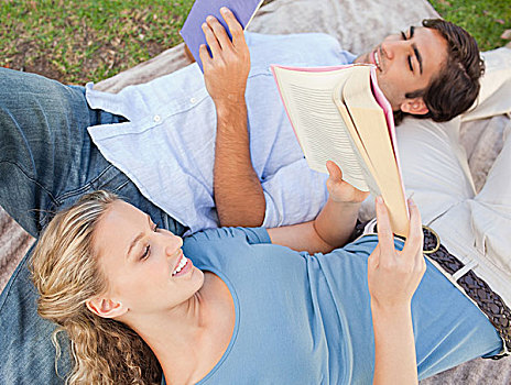 微笑,伴侣,躺着,草地,读,书本