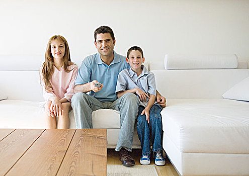 父亲,两个孩子,坐,沙发,指向,遥控器