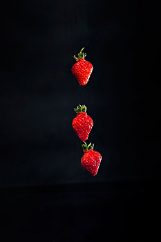 黑色背景下的悬浮草莓