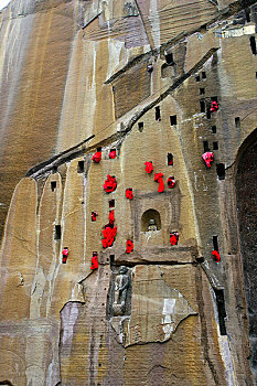 信徒在潼南大佛寺崖壁上挂的红纸