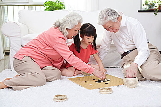 一對(duì)老年夫婦和孫女下圍棋