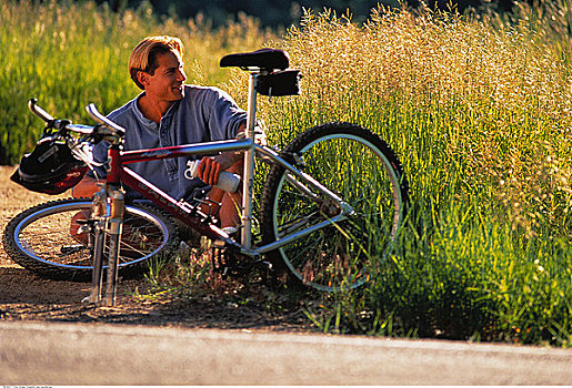 男人,坐,靠近,高草,修理,自行车
