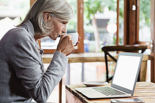 侧面视角,老年,女人,喝咖啡,使用笔记本,电脑,坐,桌子,咖啡,店