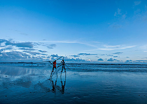 广西东兴京族万尾岛金滩渔民踩着高跷捕鱼捞虾