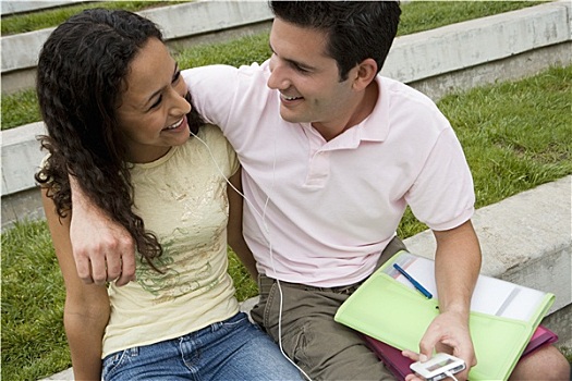 年轻,情侣,17-19岁,听,mp3播放器,分享,耳机,男孩,搂抱,女孩