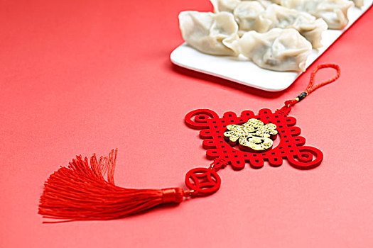 饺子中国结和剪纸放在红色背景上