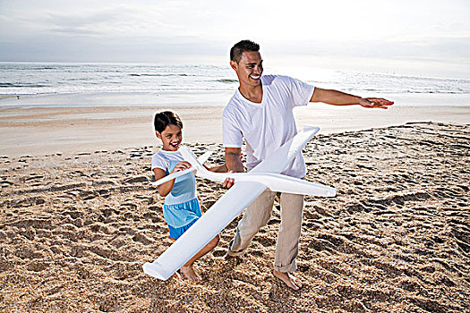 西班牙裔,爸爸,女孩,玩,玩具飞机,海滩