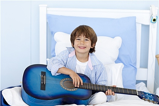 高兴,小男孩,弹吉他,床上