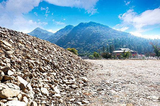 蓝天下泥石道路与远处群山山脉