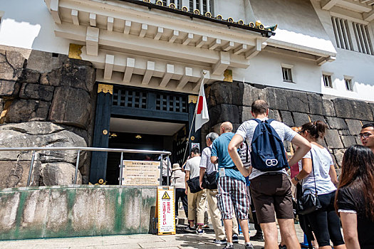 游客们正排队登上大阪城公园的天守阁