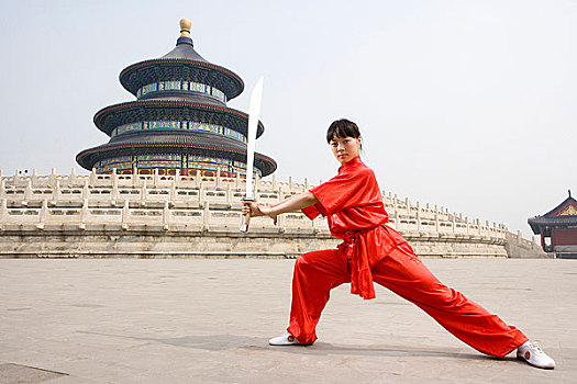 中国武术--一名女武术运动员在天坛祈年殿前练刀法