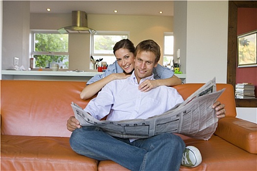 女人,搂抱,男人,坐,沙发,报纸,微笑