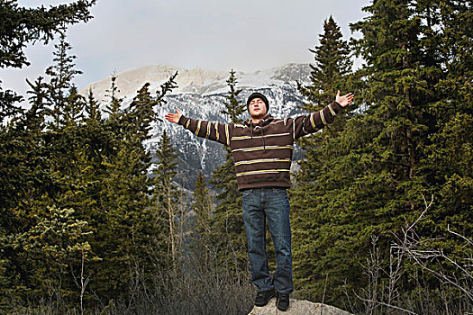 碧玉国家公园,艾伯塔省,加拿大,男青年,站立,石头,抬臂,山,背景