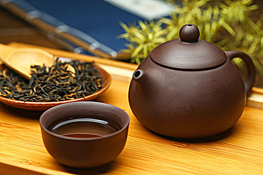 紫砂壶茶具和茶叶放在竹盘上