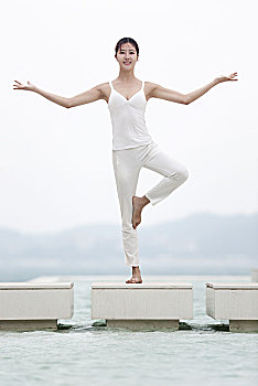 站在白色建筑上的瑜伽美女