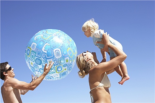 年轻家庭,玩,海滩,父亲,拿着,水皮球,母亲,举起,女儿,2-3岁,高处,头部
