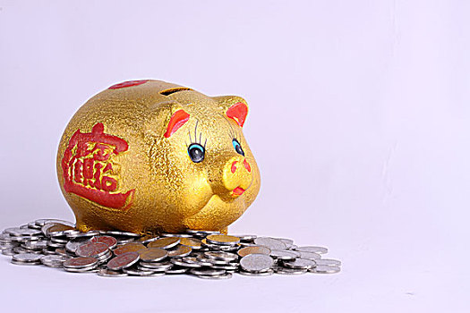 金色小猪存钱罐和散落在周围的硬币