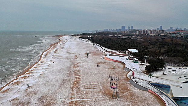 龙年瑞雪悄然而至,游客漫游海边赏雪打卡