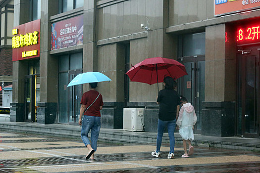 山东省日照市,台风烟花威力不减,带来大风降雨行人艰难赶路回家