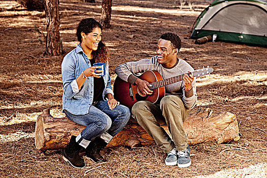 年轻,情侣,坐,树林,原木,演奏,木吉他