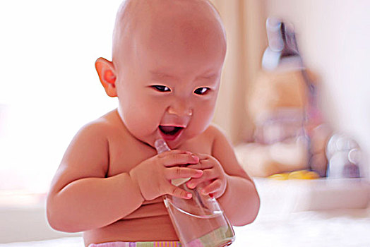 抱着奶瓶张着嘴的婴儿