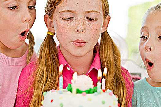 特写,三个女孩,吹蜡烛,生日蛋糕