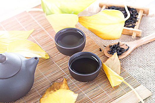 经典的黑色茶壶和秋季的落叶
