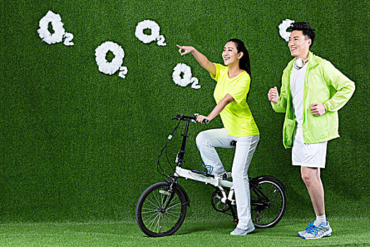 草地创意年轻情侣骑自行车