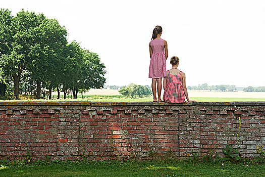 两个女孩,砖墙