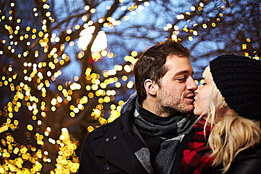 年轻,情侣,吻,正面,户外,圣诞灯光