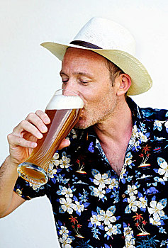男人,戴着,草帽,夏威夷衫,喝,小麦啤酒