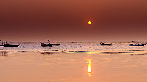 广西涠洲岛落日海滩的落日与小船