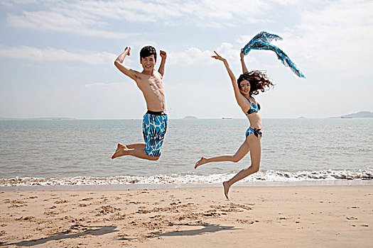 情侣在沙滩跳跃