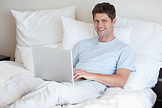微笑,男人,卧,床上,笔记本电脑