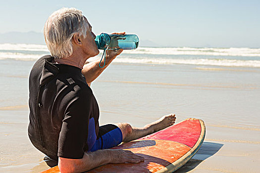 侧面视角,老人,饮用水,坐,冲浪板,海滩