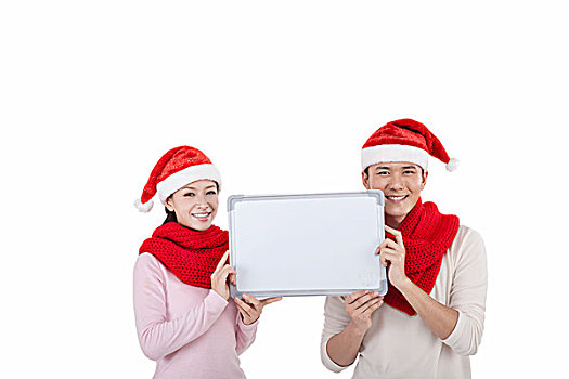 戴着圣诞帽的青年伴侣拿着白板