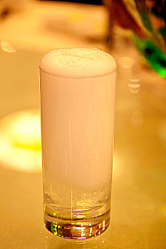 雪碧的泡沫溢出透明的玻璃杯