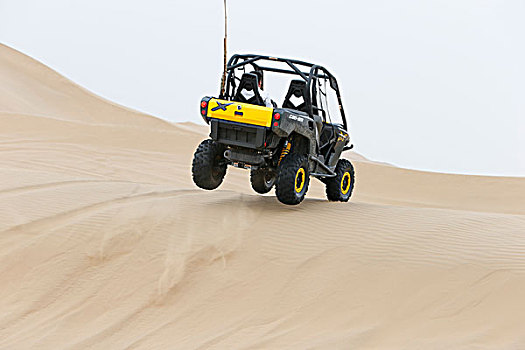 人驾驶着海滩车在沙漠上