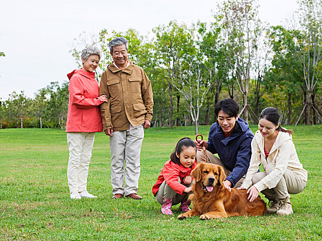 快乐的五口之家和宠物狗在公园玩耍