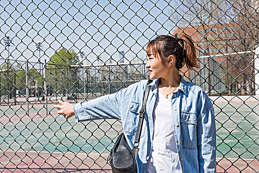 年轻漂亮的女学生在操场边