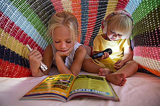 女孩,幼儿,姐妹,躺着,床,隐藏,毯子,手电筒,读,杂志