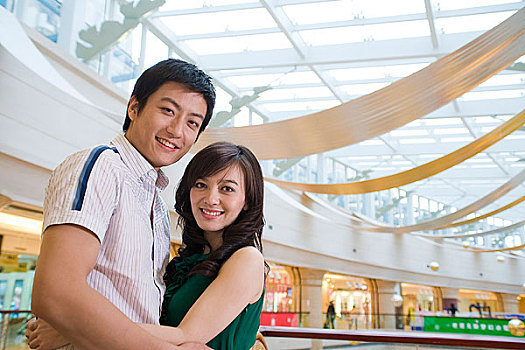 快乐的年轻情侣在商场拥抱