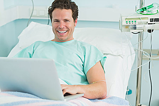 微笑,男患者,打字,笔记本电脑,躺着,床,医院